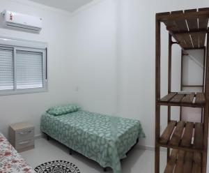 een slaapkamer met een stapelbed en een ladder bij Ap 203 - Mônaco Residence - rua na Beira da Praia - Não aceita pet in Florianópolis