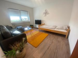 ein Wohnzimmer mit einem Sofa und einem Bett in der Unterkunft Ferienwohnung Wasserturmblick in Bebra