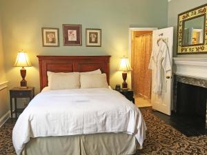 um quarto com uma cama branca e uma lareira em Morris House Hotel em Filadélfia