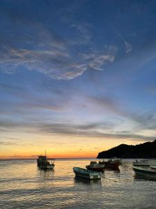 a group of boats sitting in the water at sunset at Apartamento Mattos in Taganga