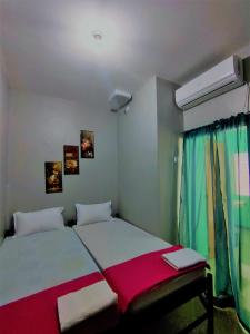 a bedroom with a bed with a red and white blanket at Innskeep in Calingcuan