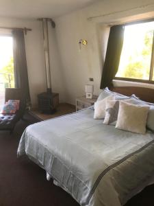 - une chambre dotée d'un grand lit avec des draps et des oreillers blancs dans l'établissement Costa del Sol de Rapel, à La Estrella