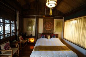 um quarto com uma cama e um lustre em Lv Ye An Jia 绿野安家 em Lijiang