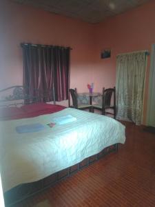 1 dormitorio con 1 cama y 1 mesa con sillas en ห้องพัก โฮมทรัพย์ en Ban Thung Pla Kat