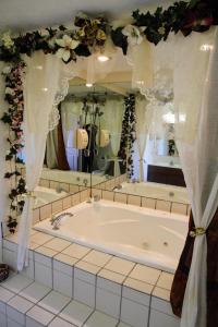 a bath tub in a bathroom with a large mirror at Country Hearth Inn-Union City in Union City