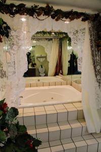 a large bath tub in a bathroom with a mirror at Country Hearth Inn-Union City in Union City