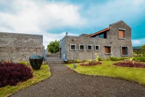 a stone house with a garden in front of it at Viveda Wellness Resort in Nashik