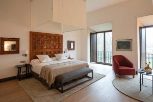 1 dormitorio con 1 cama y 1 silla roja en Parador de Turismo de León, en León