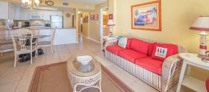 een woonkamer met een rode bank en een keuken bij Sunswept 108 Condo in Orange Beach
