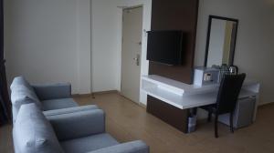 a living room with a couch and a tv at Be Boutique Hotel in Kluang