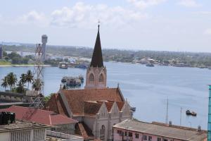 a church with a steeple and a large body of water at Rainbow Hotel in Dar es Salaam
