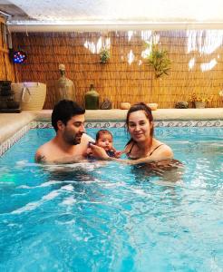 Un uomo e una donna che tengono un bambino in piscina di El Faro a Caldera