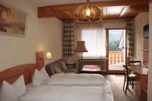 ein Schlafzimmer mit einem Bett und ein Wohnzimmer in der Unterkunft Schwarzwald-Gasthof Hirsch in Bad Wildbad