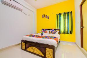 a bedroom with a bed in a yellow room at NAMAHA STAYs in Shamshabad