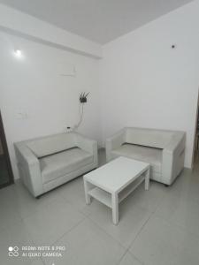 a living room with two couches and a coffee table at NAMAHA STAYs in Shamshabad