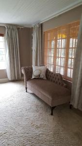 a couch sitting in a living room with windows at Invermooi Estate in Nottingham Road