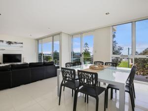 una sala da pranzo con tavolo e sedie bianchi di Solymar I Adjacent to Beach I Pet Friendly a Callala Bay