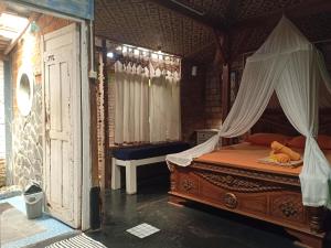 a bedroom with a bed with a canopy at Arjuna Garden Homestay in Yogyakarta