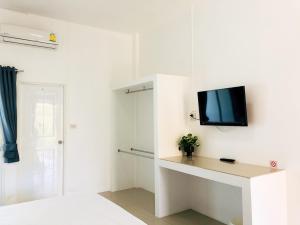 a white room with a tv on a wall at Baanlugchange Hotel in Chanthaburi