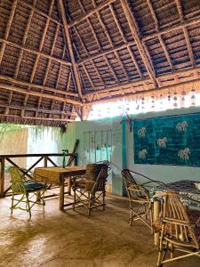 une chambre avec des chaises, une table et un plafond dans l'établissement Mawingu lodge, à Kizimkazi