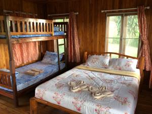 a bedroom with two bunk beds in a cabin at The Memory of Khaokho in Phetchabun