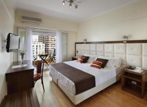 Un dormitorio con una cama grande y un televisor. en Hotel Impala, en Buenos Aires