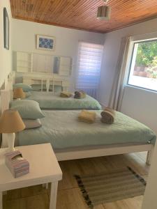 um quarto com três camas e uma mesa e uma janela em Hemel-en-See Beach House em Hermanus