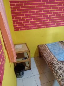 a small room with a bench and a brick wall at Penginapan Dinafizka in Bogor