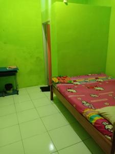 una camera con un letto in una stanza verde di Penginapan Dinafizka a Bogor