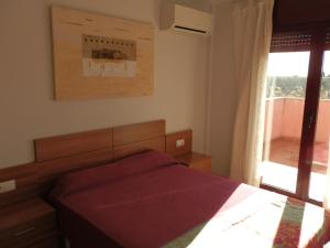 a bedroom with a red bed and a window at Casa Bonita in Riumar +9 photos