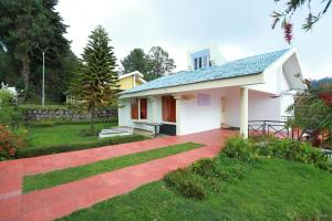 a white house with a red brick driveway at Fortune Retreats in Ooty