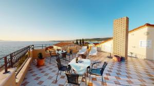 a woman is sitting at a table on a balcony at Casa Del Sol Bed&Breakfast in Sukošan