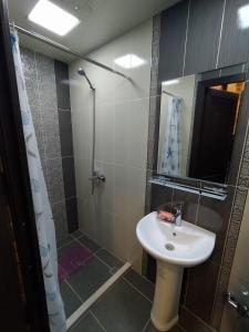 uma casa de banho com um lavatório e um chuveiro com um espelho. em apartament oriental tale in old cyti Baku em Baku