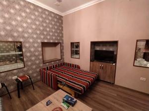 a living room with a couch and a tv at apartament oriental tale in old cyti Baku in Baku