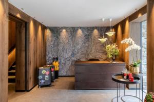 a lobby with a stone wall and a table at Hotel ZERMAMA Zermatt in Zermatt