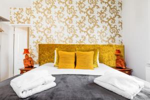 a bedroom with a large bed with a yellow headboard at Ashbys Accommodation & Spa hire in Portsmouth