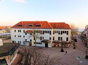 フリードリヒスハーフェンにあるBodenSEE Friedrichshafen City Apartment "WALTRAUD"の赤い屋根の大きな白い建物