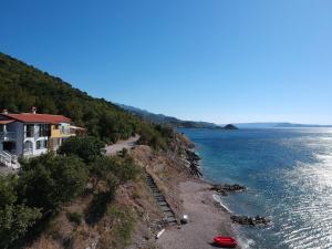 a house on a cliff next to the water at Apartments Turina in Sveti Juraj