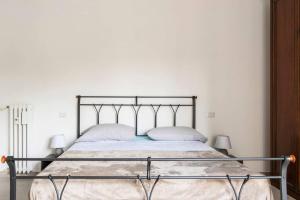 1 cama con marco de metal en un dormitorio en Appartamento Michelino - in fiera portello, en Milán