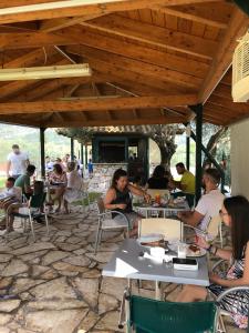 a group of people sitting at tables in a patio at Villa Agni in Yenion