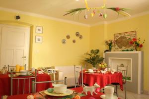 a living room with yellow walls and a table with red table cloth at Hotel Na Vodách in Mariánské Lázně