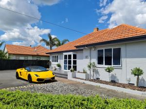 ハミルトンにあるJ&L Boarding Holiday Houseの家の前に駐車された黄色い車