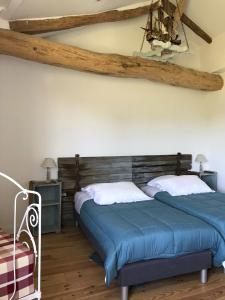 2 Betten in einem Zimmer mit Holzdecken in der Unterkunft La grange du Logis du Plessis in Chaniers