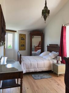 - une chambre avec un grand lit et un miroir dans l'établissement La grange du Logis du Plessis, à Chaniers