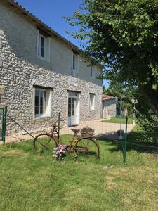 un vélo garé devant un bâtiment en pierre dans l'établissement La grange du Logis du Plessis, à Chaniers