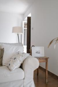 ein Wohnzimmer mit einem weißen Sofa und einem Tisch in der Unterkunft Ecoturisme Mas Ribas in Palamós
