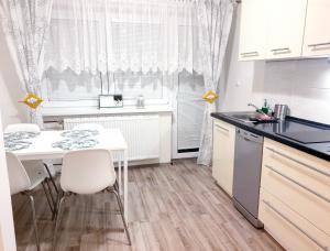 a kitchen with a white table and white chairs at Apartment Petra in Lipova Lazne