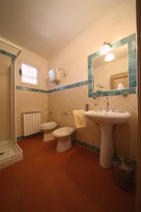 a bathroom with two toilets and a sink and a mirror at Agriturismo Caiburroni in Pietralunga