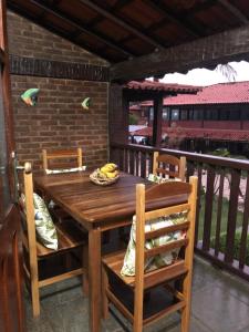 una mesa de madera y sillas en un porche en Condominio Geriba Buzios , apartamento 205, en Búzios
