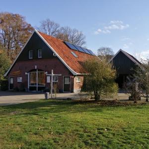 a large red barn with a red roof at Veenemaat in Winterswijk